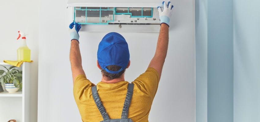 HVAC technician servicing an indoor air conditioner.
