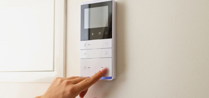 A person adjusting a wall-mounted air conditioner control.