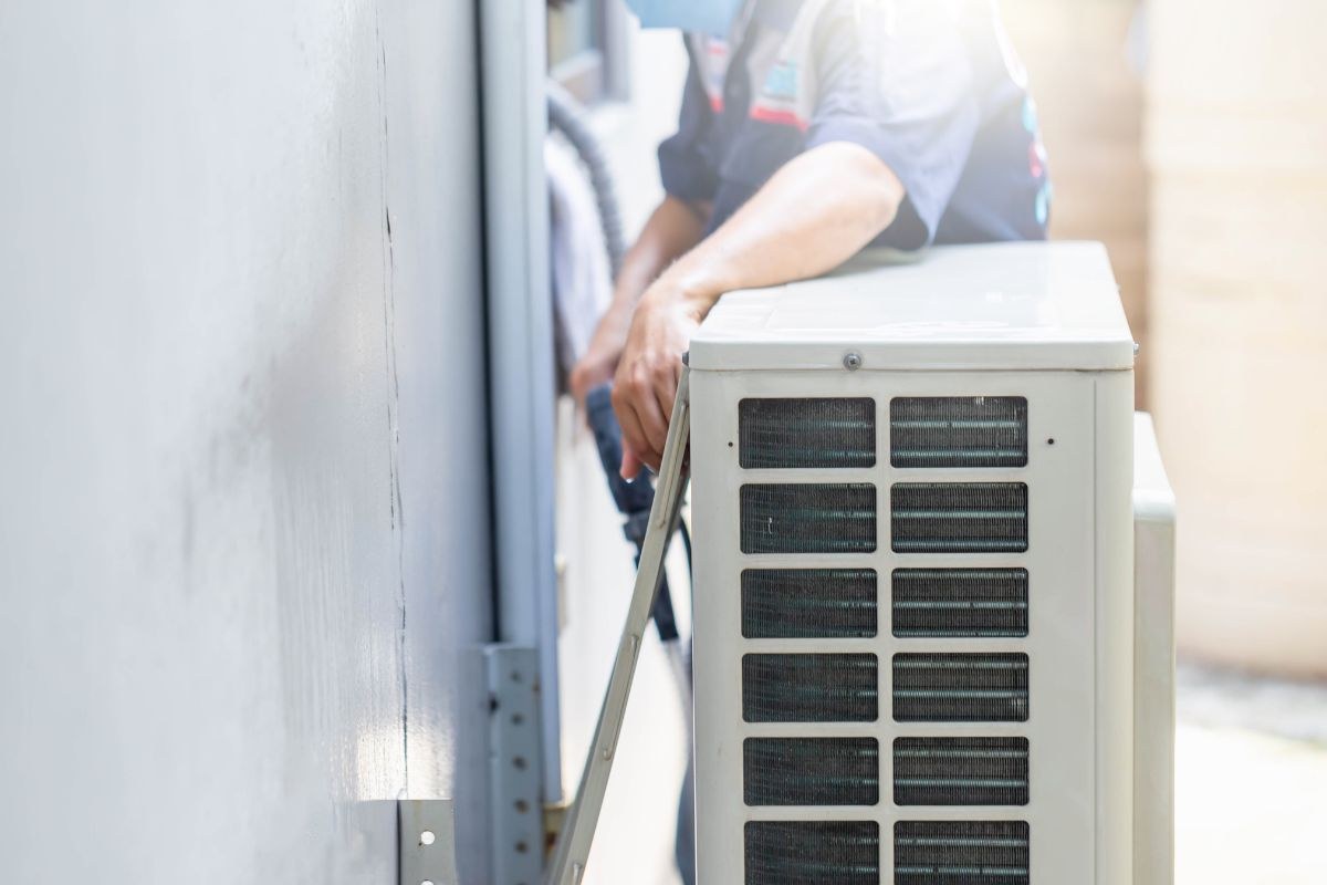 An HVAC expert checks the efficiency of the air conditioner compressor.