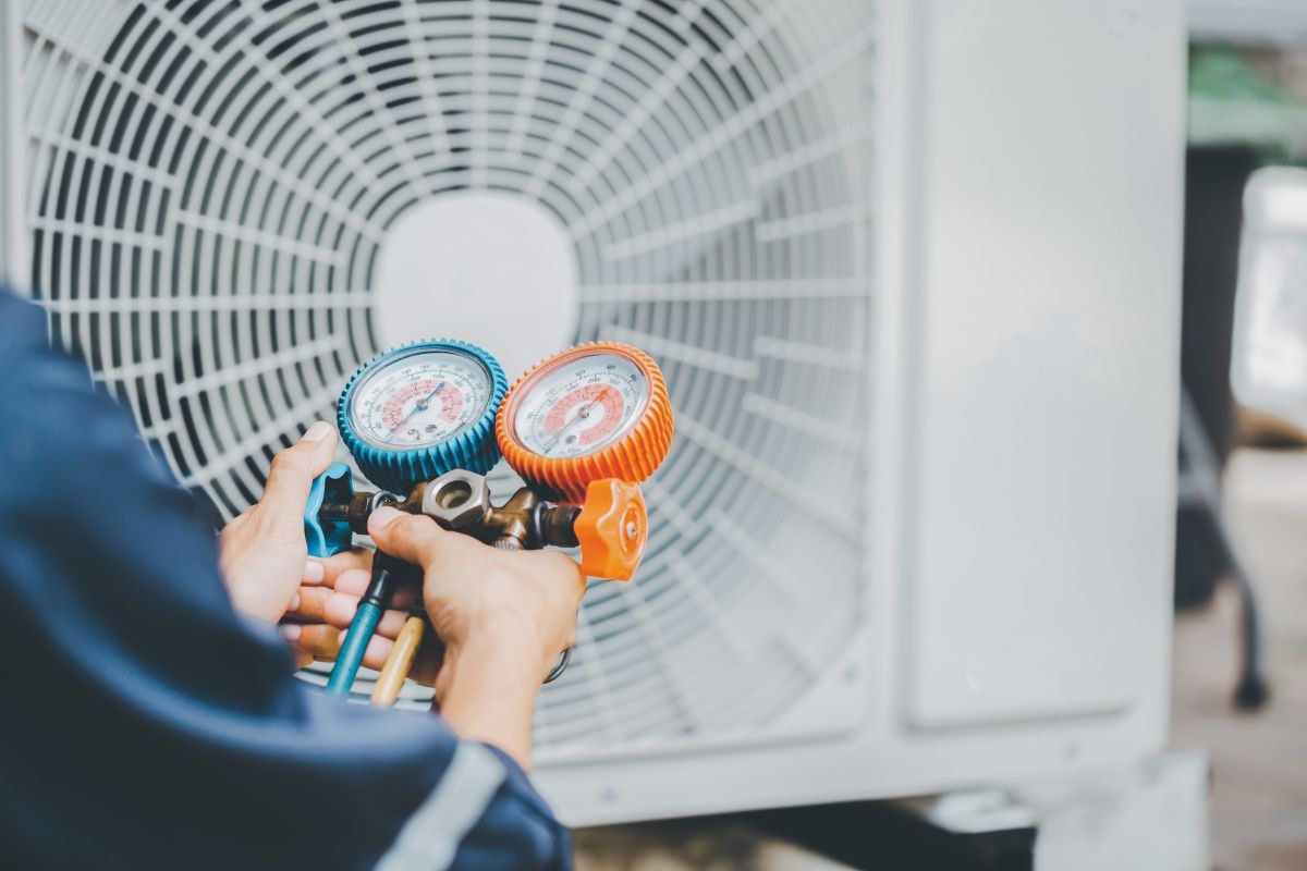 An HVAC technician installs an HVAC chiller.