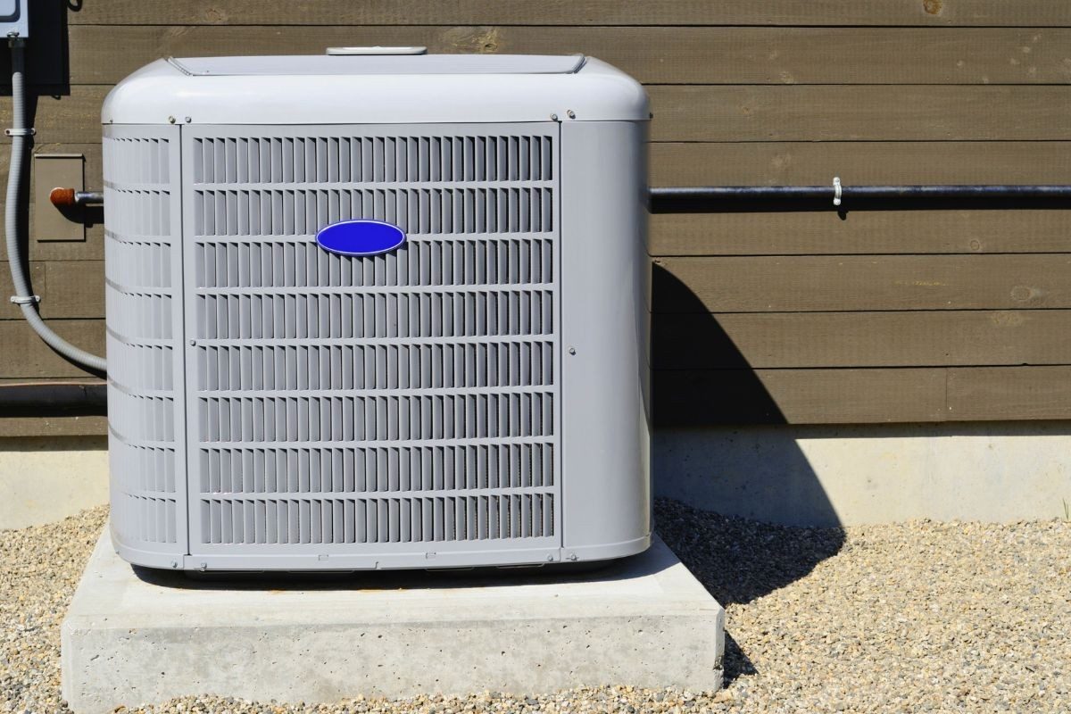 Outdoor HVAC condenser unit installed on a concrete pad beside a home.