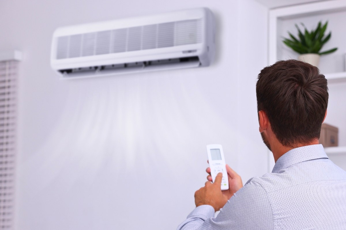 The man adjusts the cooling temperature of the AC.
