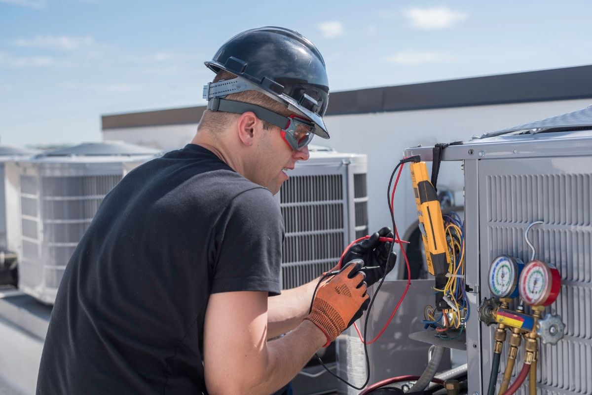 The expert installs RTU HVAC systems on the building rooftop.