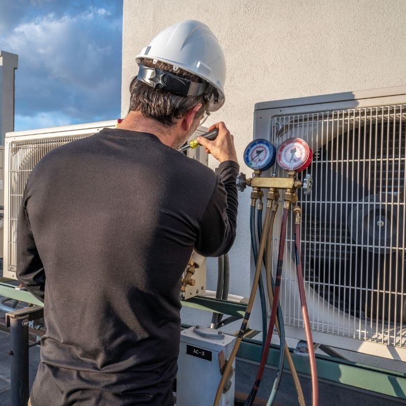 Fahrenheit AC technician servicing a commercial rooftop air conditioning unit