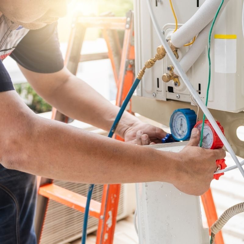 Technician connecting refrigerant lines during a ductless mini split installation