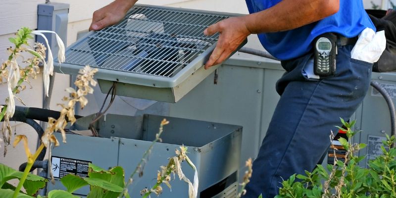 An AC technician repairs a unit.