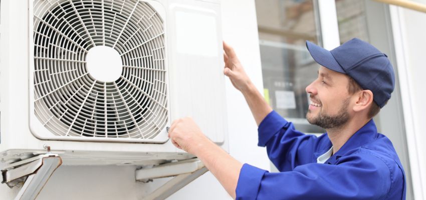 The expert installs an air conditioner.