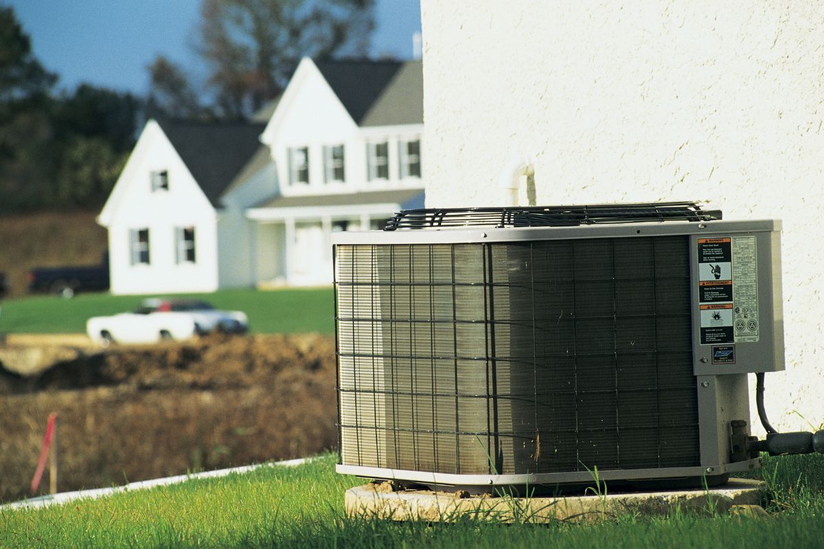 The outdoor central air conditioning unit is at the house's back.