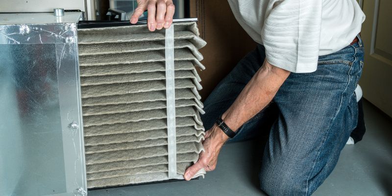 The expert pulled out the HVAC filter to wash and clean.