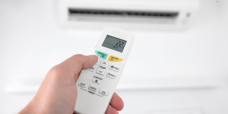 The man turns on the ductless HVAC System.