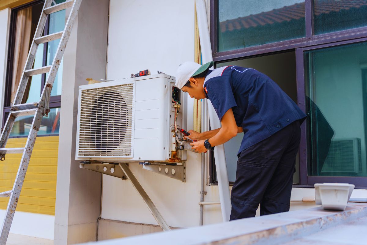 HVAC technician servicing an outdoor unit to demonstrate what is a ductless AC and how it provides efficient cooling without ducts.