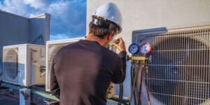 HVAC technician checking air conditioning unit pressure gauge to measure airflow efficiency — illustrating what is CFM in HVAC systems