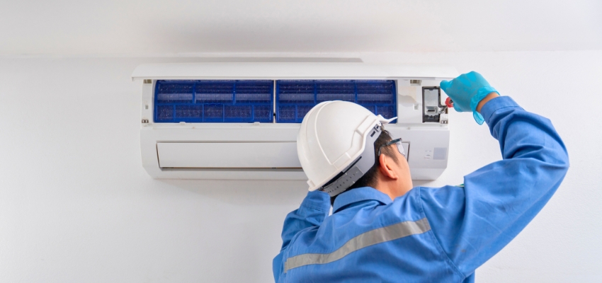The man is checking the refrigerant of the AC.