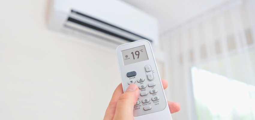 The homeowner adjusts the AC's cooling temperature.