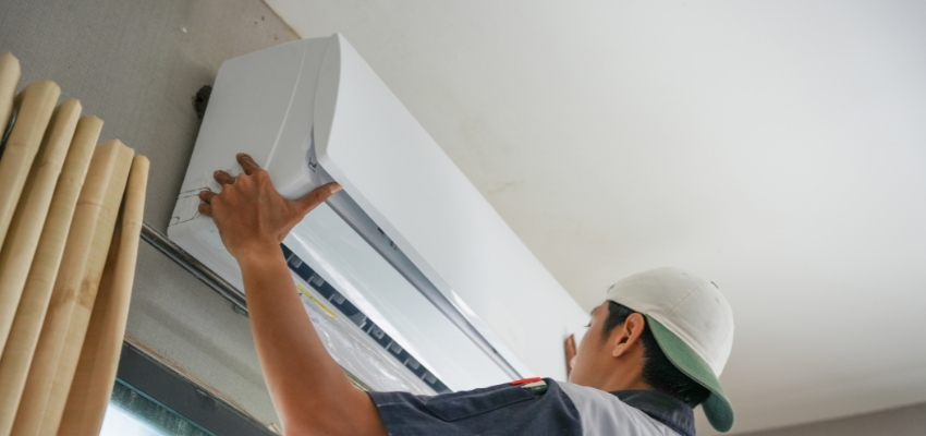 Technician installing a modern unit among popular wall air conditioners