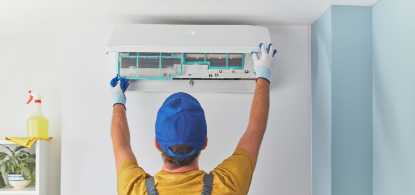 Technician working on an indoor AC unit to solve why is my ac not working