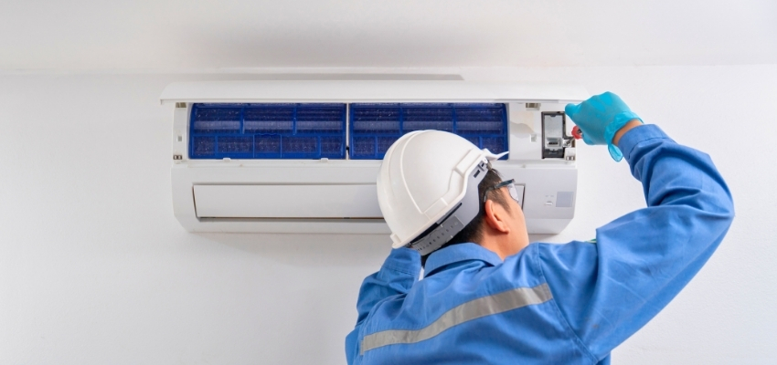 Technician cleaning an AC unit to prevent mold in air conditioner buildup