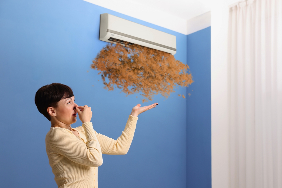 Woman reacting to debris from a unit, a clear warning of mold in air conditioner